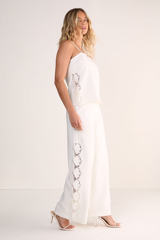 Tailored wide leg silhouette for a sophisticated, flowing look
        Distinctive cutwork detailing along the sides creates an eye-catching pattern
        High-waisted design offers a flattering fit that elongates the legs
        Clean, streamlined construction with a smooth waistband
        Versatile cotton fabric provides comfort and structure throughout the day
    
    Make a striking impression with these Nasty Gal wide leg trousers featuring intricate cutwork detailing along the sides. The tailored silhouette creates a dramatic sweep as you move, whilst the high-waisted design accentuates your natural curves. Perfect for formal occasions, pair with a sleek halter top as shown and minimal strappy heels for an elegant ensemble that commands attention. For daytime sophistication, style with a crisp button-down shirt and pointed flats. These trousers transition beautifully from summer garden parties to evening receptions, offering a contemporary alternative to traditional occasion wear. The clean lines and architectural details reflect modern British tailoring whilst maintaining a feminine aesthetic that works brilliantly for weddings, races or graduation ceremonies.