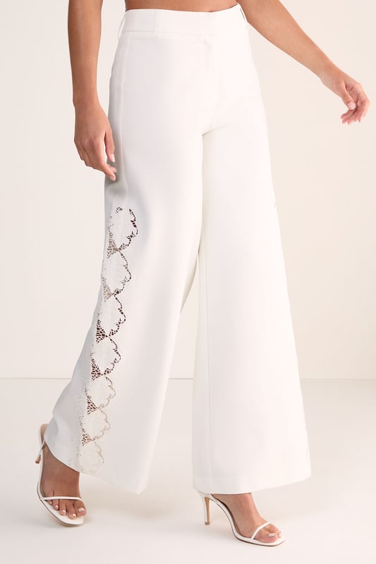 Tailored wide leg silhouette for a sophisticated, flowing look
        Distinctive cutwork detailing along the sides creates an eye-catching pattern
        High-waisted design offers a flattering fit that elongates the legs
        Clean, streamlined construction with a smooth waistband
        Versatile cotton fabric provides comfort and structure throughout the day
    
    Make a striking impression with these Nasty Gal wide leg trousers featuring intricate cutwork detailing along the sides. The tailored silhouette creates a dramatic sweep as you move, whilst the high-waisted design accentuates your natural curves. Perfect for formal occasions, pair with a sleek halter top as shown and minimal strappy heels for an elegant ensemble that commands attention. For daytime sophistication, style with a crisp button-down shirt and pointed flats. These trousers transition beautifully from summer garden parties to evening receptions, offering a contemporary alternative to traditional occasion wear. The clean lines and architectural details reflect modern British tailoring whilst maintaining a feminine aesthetic that works brilliantly for weddings, races or graduation ceremonies.