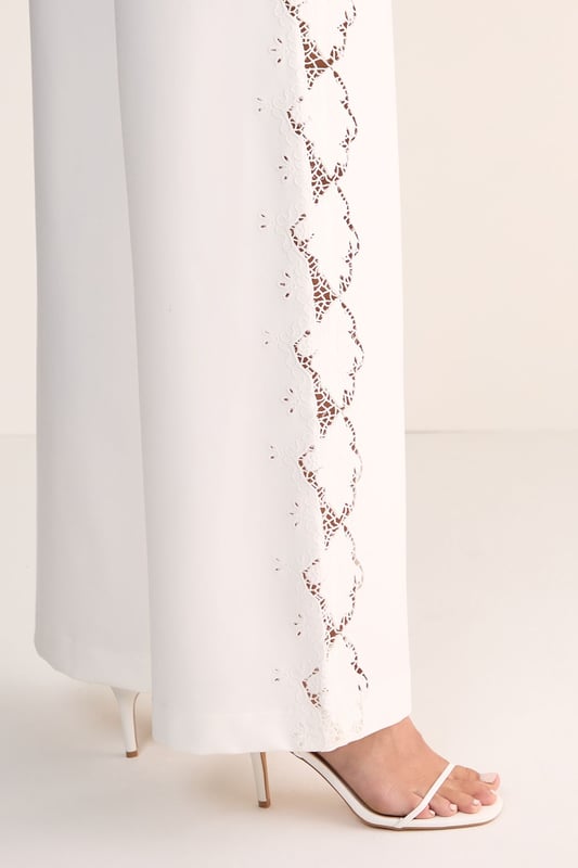 Tailored wide leg silhouette for a sophisticated, flowing look
        Distinctive cutwork detailing along the sides creates an eye-catching pattern
        High-waisted design offers a flattering fit that elongates the legs
        Clean, streamlined construction with a smooth waistband
        Versatile cotton fabric provides comfort and structure throughout the day
    
    Make a striking impression with these Nasty Gal wide leg trousers featuring intricate cutwork detailing along the sides. The tailored silhouette creates a dramatic sweep as you move, whilst the high-waisted design accentuates your natural curves. Perfect for formal occasions, pair with a sleek halter top as shown and minimal strappy heels for an elegant ensemble that commands attention. For daytime sophistication, style with a crisp button-down shirt and pointed flats. These trousers transition beautifully from summer garden parties to evening receptions, offering a contemporary alternative to traditional occasion wear. The clean lines and architectural details reflect modern British tailoring whilst maintaining a feminine aesthetic that works brilliantly for weddings, races or graduation ceremonies.