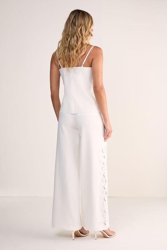 Tailored wide leg silhouette for a sophisticated, flowing look
        Distinctive cutwork detailing along the sides creates an eye-catching pattern
        High-waisted design offers a flattering fit that elongates the legs
        Clean, streamlined construction with a smooth waistband
        Versatile cotton fabric provides comfort and structure throughout the day
    
    Make a striking impression with these Nasty Gal wide leg trousers featuring intricate cutwork detailing along the sides. The tailored silhouette creates a dramatic sweep as you move, whilst the high-waisted design accentuates your natural curves. Perfect for formal occasions, pair with a sleek halter top as shown and minimal strappy heels for an elegant ensemble that commands attention. For daytime sophistication, style with a crisp button-down shirt and pointed flats. These trousers transition beautifully from summer garden parties to evening receptions, offering a contemporary alternative to traditional occasion wear. The clean lines and architectural details reflect modern British tailoring whilst maintaining a feminine aesthetic that works brilliantly for weddings, races or graduation ceremonies.