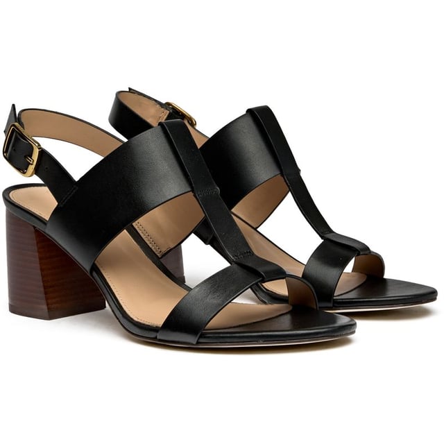 The Cole Haan Josie T-Strap elevates summer sophistication with its sleek black leather construction and striking wood-trimmed sole. At 7cm, the wedge heel delivers confident height while the cushioned insole ensures all-day comfort. The classic T-strap silhouette secured with a refined buckle closure makes this sandal an effortless transition from boardroom to bistro.