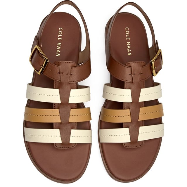 Effortless sophistication meets everyday comfort in these tan leather slides. The Cole Haan Flynn Fishman features a supple leather upper with a classic buckle detail that adds just the right touch of refinement. With a cushioned insole that cradles your feet and a durable synthetic sole, these versatile flats transition seamlessly from morning errands to evening gatherings.