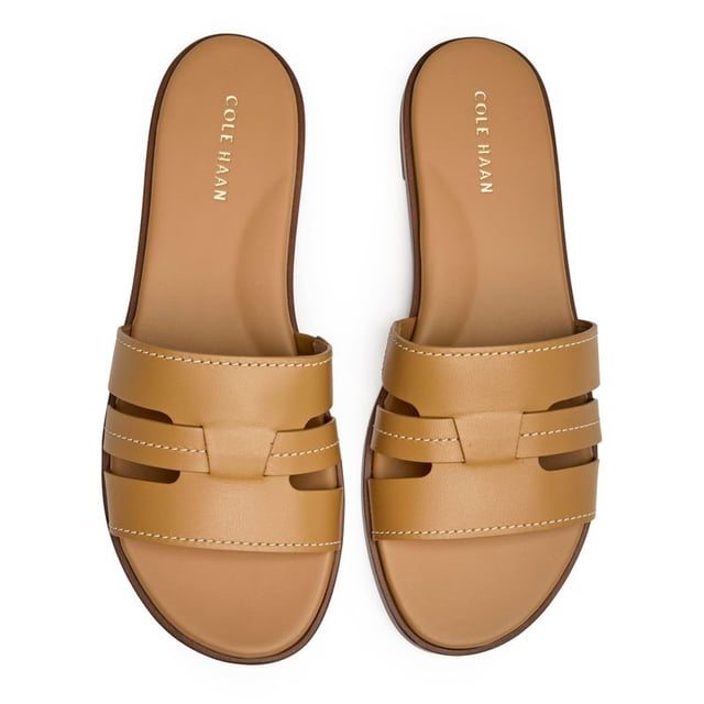 The Cole Haan Flynn slides bring effortless sophistication to your warm-weather wardrobe. Crafted with buttery leather uppers in a versatile tan shade, these flats transition seamlessly from poolside lounging to city strolling. The cushioned insole ensures all-day comfort whether you're running errands or meeting friends for brunch. Clean lines and premium materials make these slides a refined choice that pairs beautifully with everything from sundresses to tailored shorts.