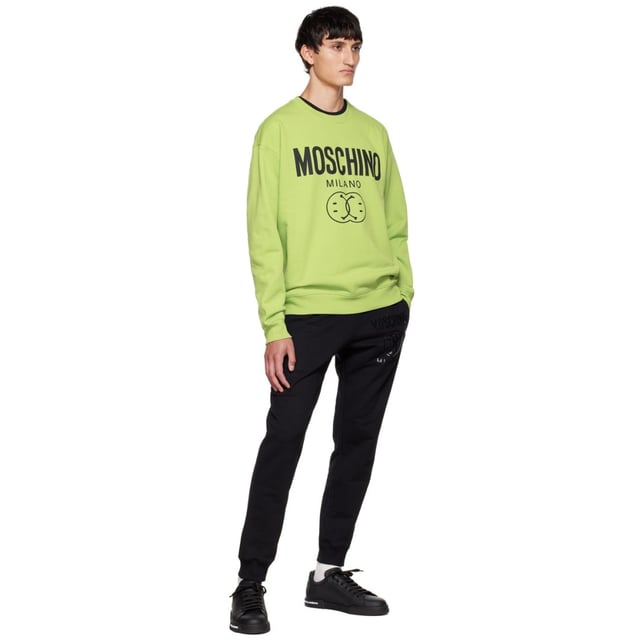 Elevate your wardrobe with the Moschino Double Smiley Green Jumper, a vibrant and playful piece that combines comfort with bold style. Crafted from high-quality materials, this jumper features Moschino's iconic double smiley design in a striking green hue, perfect for adding a cheerful touch to any outfit. Its soft fabric ensures all-day comfort, while the eye-catching print makes a confident fashion statement. Ideal for casual outings or relaxed weekends, this jumper effortlessly blends fun and sophistication, making it a must-have addition to your collection. Embrace positivity and stand out with Moschino's unique flair. Made in Portugal, 100% Cotton