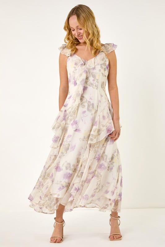 Dusk Floral Print Ruffle Maxi Dress from Roman. Make a stunning entrance this Spring Summer season in this floral print maxi dress. Embrace your feminine side with the v-neckline and flutter sleeves adorned with delicate ruffle detailing. The blooming floral print adds a touch of romance, while the comfortable woven chiffon fabric ensures a flattering flowy silhouette at maxi length. Complete the look with a bolero and heels for any special occasion!