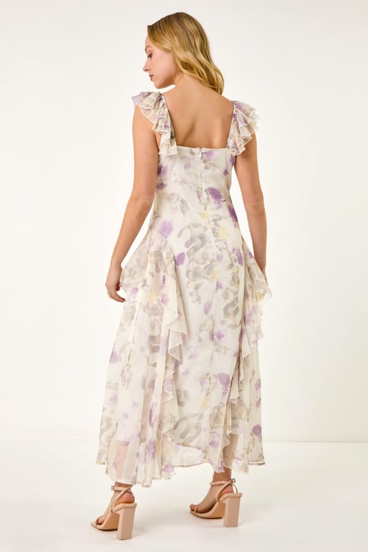 Dusk Floral Print Ruffle Maxi Dress from Roman. Make a stunning entrance this Spring Summer season in this floral print maxi dress. Embrace your feminine side with the v-neckline and flutter sleeves adorned with delicate ruffle detailing. The blooming floral print adds a touch of romance, while the comfortable woven chiffon fabric ensures a flattering flowy silhouette at maxi length. Complete the look with a bolero and heels for any special occasion!