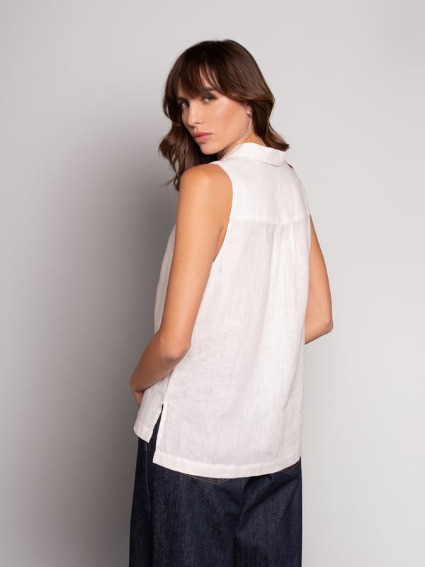 This woven sleeveless blouse features a polo collar with a V-neck and buttoned half placket. The box pleat detail at the front of the blouse adds fullness for a body-skimming, flattering silhouette. The coconut buttons and the stepped hem, complete the look. Crafted from crisp yarn-dyed linen, with a unique variegated look to the weave.