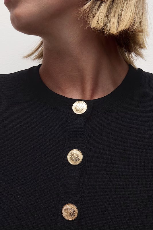 This short sleeve cardigan is crafted from a textured knit for a breezy feel, perfect for layering. Cut in a boxy fit, it features a crew neckline and a button-through front.

20" Shoulder to Hem.

As clearance stock, brand labels have been snipped.