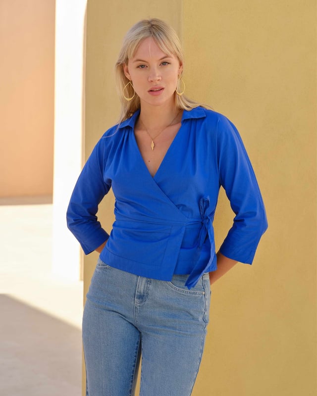 Embrace sophistication with this fitted wrap-style shirt, perfect for day-to-evening occasions. Featuring 3/4 length sleeves, pleated shoulders, cuffs, and adjustable side ties, it offers a flattering silhouette.