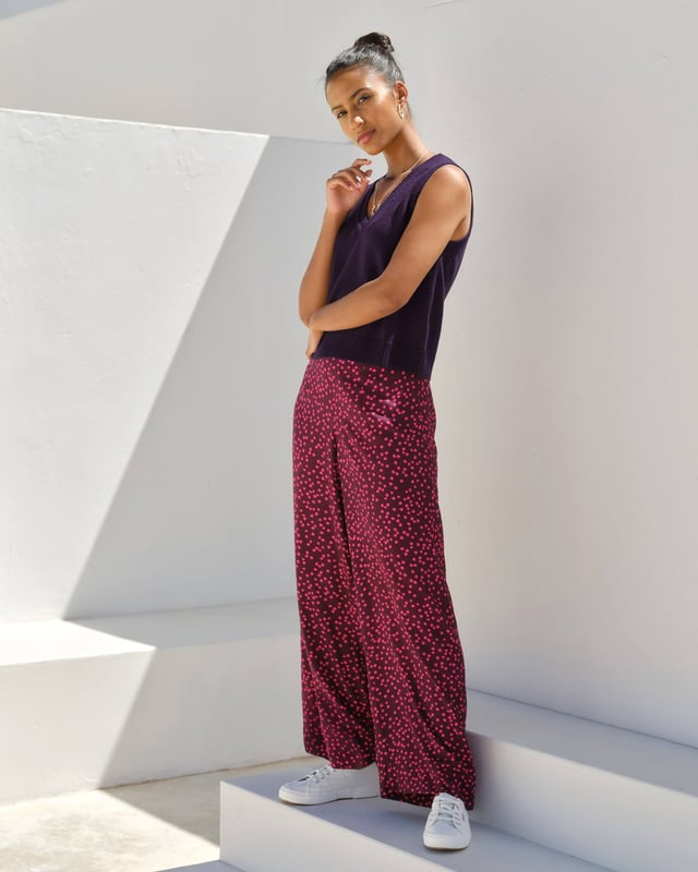 Joni Print Trousers Elevate your wardrobe with these versatile print trousers, perfect for transitioning from day to evening with effortless style. The wide-leg design, straight from thigh to hem, offers a flattering silhouette for all body types. A flat front waistband with a discreet back elastic panel ensures a comfortable, flexible fit. Part of the chic Joni Spot collection, these full-length trousers are an updated version of our popular Zoe Print design.