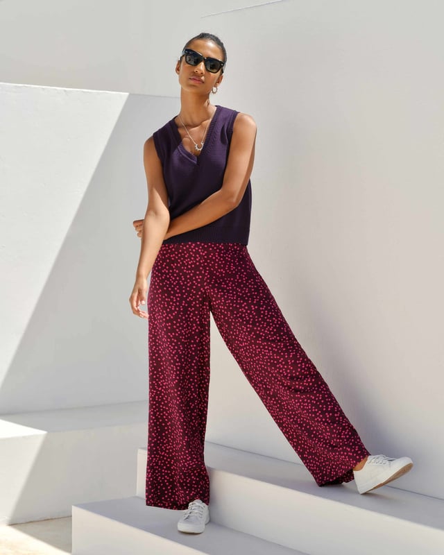 Joni Print Trousers Elevate your wardrobe with these versatile print trousers, perfect for transitioning from day to evening with effortless style. The wide-leg design, straight from thigh to hem, offers a flattering silhouette for all body types. A flat front waistband with a discreet back elastic panel ensures a comfortable, flexible fit. Part of the chic Joni Spot collection, these full-length trousers are an updated version of our popular Zoe Print design.