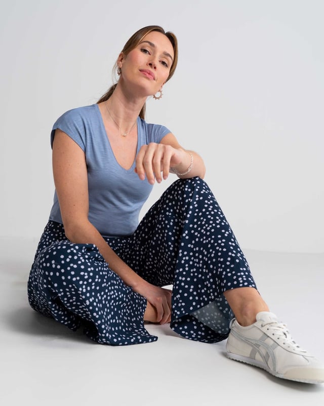 Joni Print Trousers Elevate your wardrobe with these versatile print trousers, perfect for transitioning from day to evening with effortless style. The wide-leg design, straight from thigh to hem, offers a flattering silhouette for all body types. A flat front waistband with a discreet back elastic panel ensures a comfortable, flexible fit. Part of the chic Joni Spot collection, these full-length trousers are an updated version of our popular Zoe Print design.