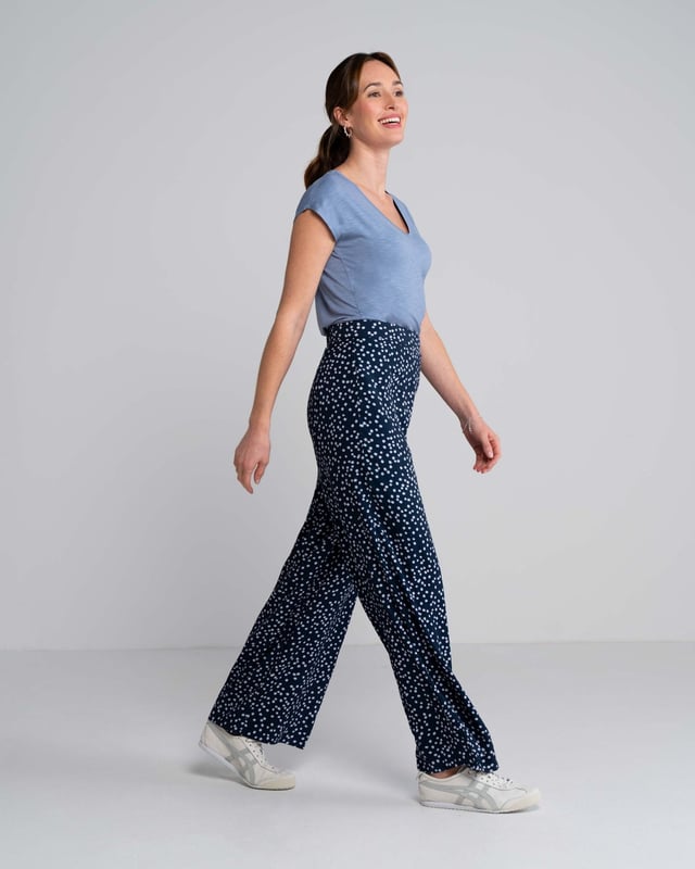 Joni Print Trousers Elevate your wardrobe with these versatile print trousers, perfect for transitioning from day to evening with effortless style. The wide-leg design, straight from thigh to hem, offers a flattering silhouette for all body types. A flat front waistband with a discreet back elastic panel ensures a comfortable, flexible fit. Part of the chic Joni Spot collection, these full-length trousers are an updated version of our popular Zoe Print design.