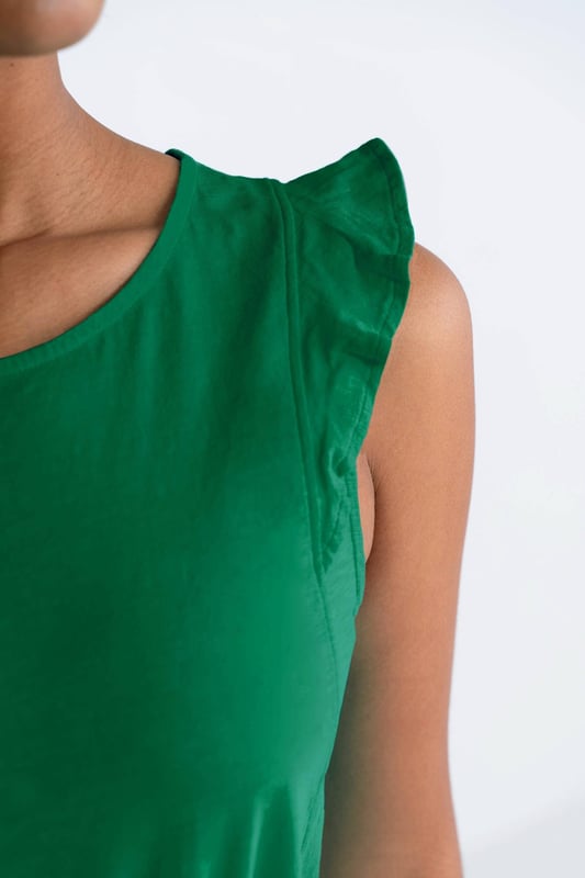 This sleeveless top features a neat neckline and charming frill shoulder detail, perfect for your holiday wardrobe. The regular fit ensures comfort, while the elegant design adds a touch of femininity.