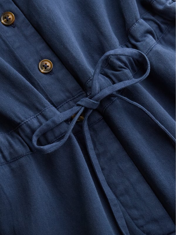 With a collared neckline and relaxed fit, this jumpsuit features a drawstring waistband for an adjustable silhouette. Crafted from  cotton, it provides both comfort and versatility, making it a go-to choice for effortless day-to-night dressing.