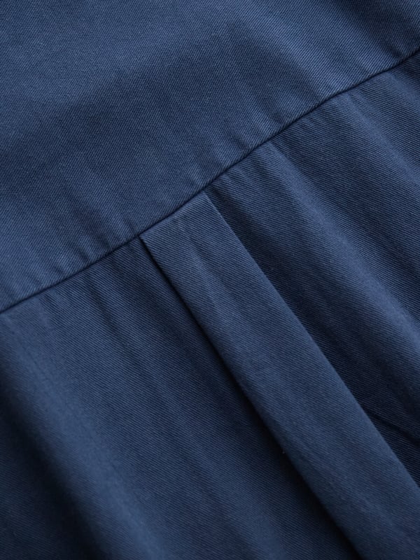 With a collared neckline and relaxed fit, this jumpsuit features a drawstring waistband for an adjustable silhouette. Crafted from  cotton, it provides both comfort and versatility, making it a go-to choice for effortless day-to-night dressing.