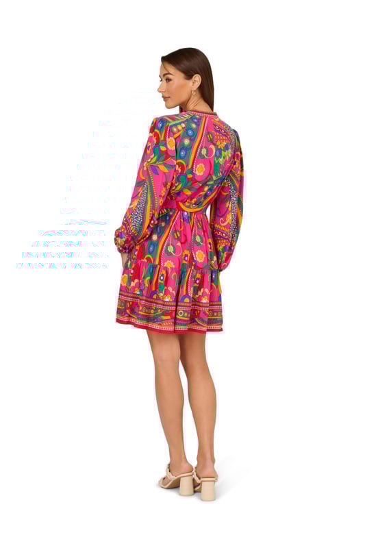 Printed Short Dress Bring a vintage vibe to your plans when you step into this long sleeve dress. This dress features a mandarin collar, v-neckline, and button up front. Crafted from woven rayon covered in all over retro abstract print, this dress boasts bishop sleeves, a soft skirt, and a self-tie waist. Dress up this short dress with knee-high boots for a look that will work in any season or rock it during the warmer months with rattan accessories. With this retro mini dress in your closet, the options are endless.