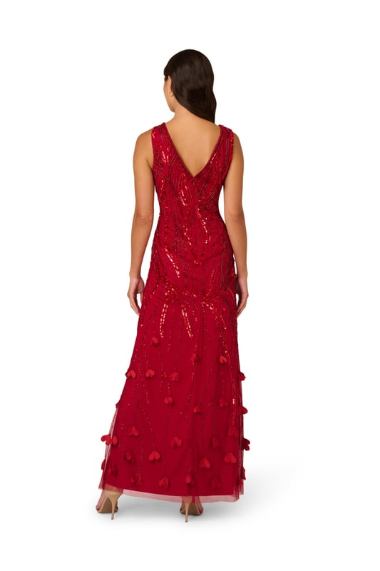 3D flower appliques trail down the skirt of this gorgeous sleeveless maxi dress for a moment of whimsical romance. The floral embellishments finish a bead and sequin design that sparkles and shimmers from the keyhole V-neckline down past the hips. The final effect of the intricate beading is to emphasize the stunning mermaid silhouette of this gown. A back zipper closure ensures the perfect fit. Wear this sumptuous gown to make a grand entrance at your next event.