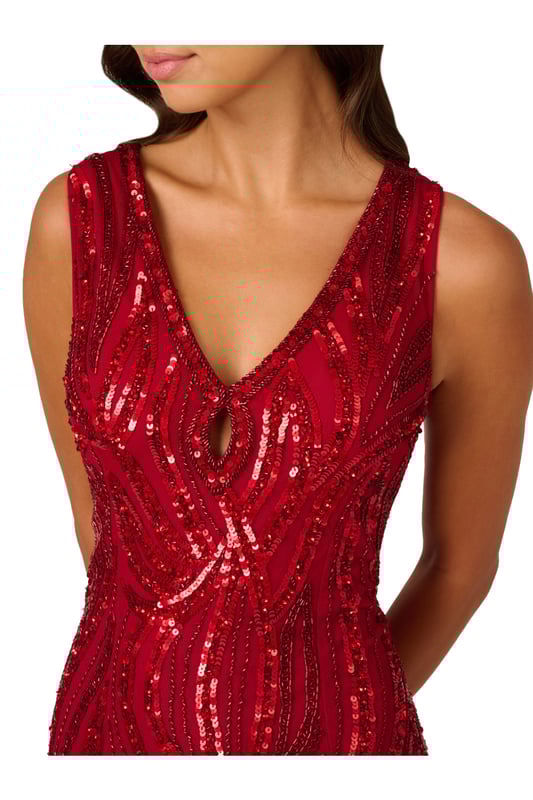 3D flower appliques trail down the skirt of this gorgeous sleeveless maxi dress for a moment of whimsical romance. The floral embellishments finish a bead and sequin design that sparkles and shimmers from the keyhole V-neckline down past the hips. The final effect of the intricate beading is to emphasize the stunning mermaid silhouette of this gown. A back zipper closure ensures the perfect fit. Wear this sumptuous gown to make a grand entrance at your next event.