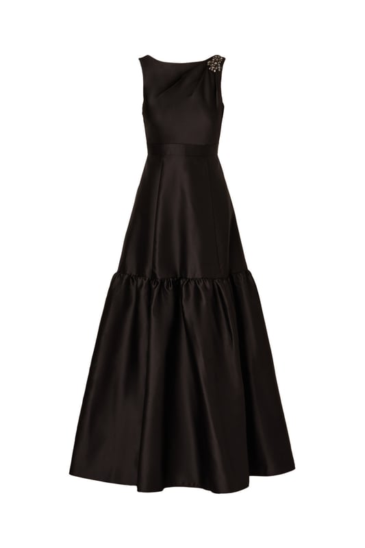 With details this luxurious, you will feel like royalty in this sleeveless ball gown. This formal dress features a sleeveless bodice, boat neckline, and a soft skirt with flounce hem. Designed with shining mikado fabric, this classic evening gown is pleated at the shoulder and accented with stunning stone trim. A hidden zipper closure at the centre back completes this black-tie dress. From charity balls to weddings, this sleeveless mikado gown will shine with a simple clutch and neutral heels.