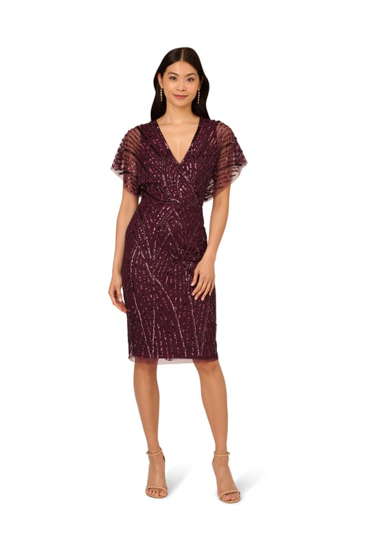 Brilliant beading brings this timeless dress to life. This beaded dress features a surplice bodice with v-neckline, sheer dolman sleeves, and a fitted skirt. Designed with a soft knit mesh fabric, this dress is embellished all over with figure-flattering patterns of sequins and beading. A zipper closure at the centre back completes this short sleeve dress. A stunning choice for elegant cocktail parties or formal weddings, this beaded dress is easy to accessorize with neutral heels and crystal jewellery.