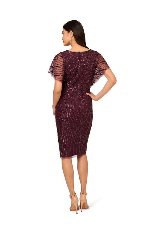 Brilliant beading brings this timeless dress to life. This beaded dress features a surplice bodice with v-neckline, sheer dolman sleeves, and a fitted skirt. Designed with a soft knit mesh fabric, this dress is embellished all over with figure-flattering patterns of sequins and beading. A zipper closure at the centre back completes this short sleeve dress. A stunning choice for elegant cocktail parties or formal weddings, this beaded dress is easy to accessorize with neutral heels and crystal jewellery.