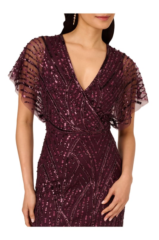 Brilliant beading brings this timeless dress to life. This beaded dress features a surplice bodice with v-neckline, sheer dolman sleeves, and a fitted skirt. Designed with a soft knit mesh fabric, this dress is embellished all over with figure-flattering patterns of sequins and beading. A zipper closure at the centre back completes this short sleeve dress. A stunning choice for elegant cocktail parties or formal weddings, this beaded dress is easy to accessorize with neutral heels and crystal jewellery.