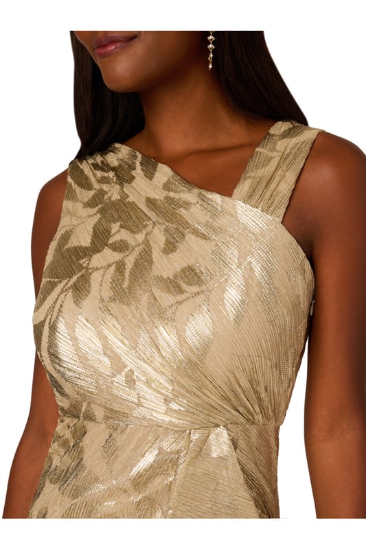 Foil Asymmetric Gown Take your style to the next level with this edgy foiled dress. This formal dress features an asymmetrical neckline, draped details through the body, and ruffle trim at the waist. Crafted from foiled and printed novelty fabric, this sleeveless dress is an eye-catching look with some stretch. A slit at the side of the mermaid skirt and a side zipper closure completes this evening gown. Paired with nude heels and a simple clutch, this printed gown is a charming look.