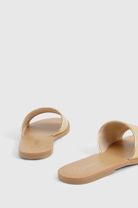 Raffia Mule Sandal Textured bast-style slide sandals with a single wide strap design
Flat heel measuring between 0-2cm for all-day comfort
Open toe silhouette perfect for showcasing pedicures
Slip-on style for effortless wear
Versatile neutral tone that complements any summer outfit
These minimalist bast-style sandals from Boohoo combine simplicity with versatility for your warm-weather wardrobe. The understated design features a comfortable flat sole that's ideal for city exploring or beachside strolls. Style them with cropped linen trousers and an oversized shirt for casual daytime outings, or pair with a flowing maxi dress for family gatherings and garden parties. The neutral tone works brilliantly with bold prints and patterns, making these sandals a true wardrobe staple. For festival season, match them with denim shorts and a graphic tee, adding layered jewellery for a touch of bohemian flair. Their lightweight construction makes them perfect for packing in your holiday suitcase, whilst the durable sole ensures they'll remain a favourite throughout the summer months.