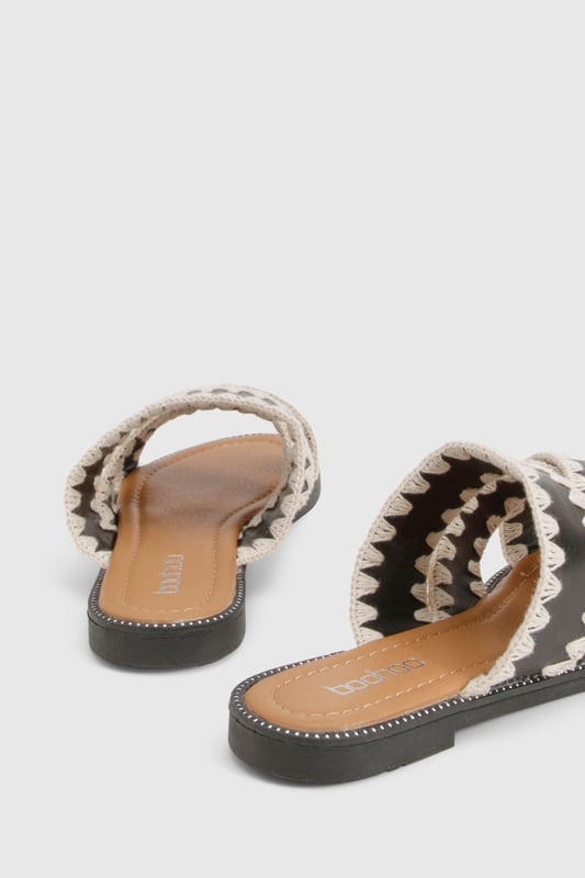 Contrast Blanket Stitch Crossover Sandals Striking contrast cross-over design with distinctive zig-zag stitching detail
Comfortable flat heel measuring between 0-2cm for all-day wear
Open-toe silhouette with dual cross-over straps for a secure fit
Durable PU construction with textured sole for added grip
Slip-on style for effortless wearing and removal
These eye-catching cross-over sandals bring a touch of artisanal flair to your casual wardrobe. The distinctive contrast stitching creates a bold visual statement whilst maintaining a relaxed vibe perfect for summer styling. Pair with cropped linen trousers and an oversized shirt for daytime outings, or team with a flowing maxi dress for garden parties and family gatherings. The flat design ensures comfort for extended wear, making these sandals ideal for city explorations or beachside strolls. Their versatile aesthetic works brilliantly with both neutral and vibrant ensembles, allowing you to customise your look according to the occasion. A statement bangle, as shown on the model, completes the look with a contemporary twist - the perfect finishing touch for these Boohoo sandals that balance style and practicality with effortless charm.