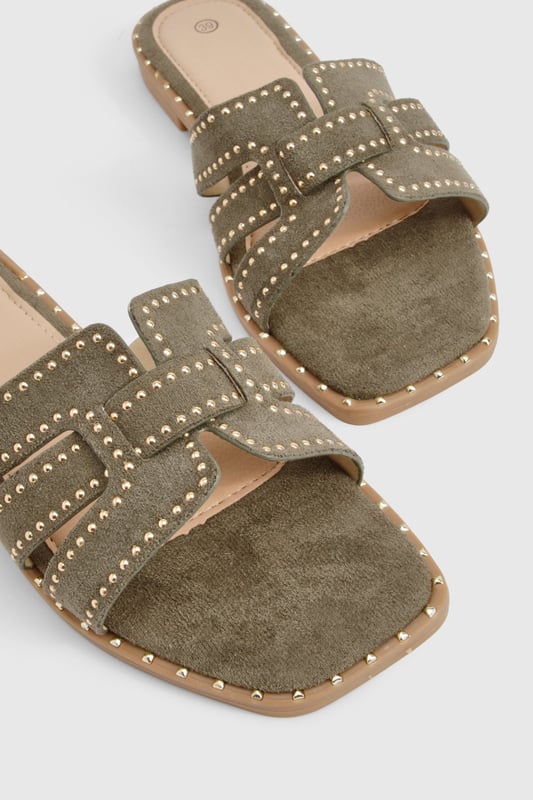 Cut Out Studded Strap Slider Flat Sandals Striking cut-out design with decorative studded straps for a contemporary edge
Flat sole with subtle stitch detailing around the edge for added durability
Open-toe silhouette offering maximum comfort during warmer days
Slip-on style for effortless wear and convenience
Versatile neutral tone that complements a variety of outfits
These chic cut-out sandals combine style and practicality for your everyday summer wardrobe. The distinctive studded straps create visual interest while maintaining a relaxed aesthetic that's perfect for casual outings. Style them with a flowing midi dress and woven bag for farmers' markets and weekend brunches, or pair with cropped linen trousers and a simple tee for shopping trips and coffee dates. The flat design ensures all-day comfort without compromising on style, making these sandals ideal for city breaks where extensive walking is required. For beach holidays, wear them with denim shorts and an oversized shirt as a stylish alternative to flip-flops. Their versatile design transitions seamlessly from daytime casual to relaxed evening gatherings, offering excellent value for your summer footwear collection.