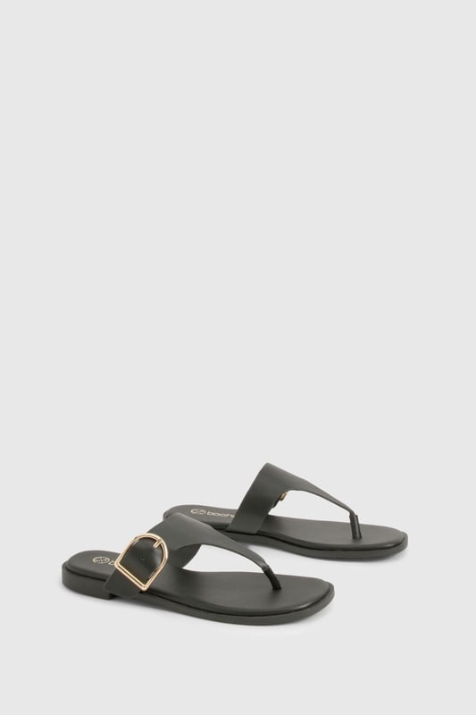 Stylish toe-post design with distinctive buckle detail for a contemporary twist
        Flat heel measuring between 0-2cm for all-day comfort and easy walking
        Sleek thong strap with smooth finish for minimal irritation between toes
        Durable sole with subtle grip pattern for poolside and beachfront stability
        Adjustable side buckle feature adds both functionality and visual interest
    
    These chic flip-flops from Boohoo combine practicality with understated style, perfect for the fashion-forward woman who values both comfort and aesthetic appeal. The distinctive buckle detail transforms a casual summer essential into a versatile accessory that works beyond the beach. Pair with flowing maxi dresses and oversized sunglasses for a relaxed daytime look, or team with cropped linen trousers and a fitted tee for casual weekend brunches. The flat design ensures comfortable wear throughout long summer days, whether you're navigating cobbled streets on holiday or attending a casual garden party. Their minimalist design makes them an excellent choice for packing light whilst maintaining style options - simply slip them on with denim shorts and a loose blouse for effortless warm-weather dressing that transitions seamlessly from day to evening.