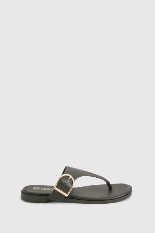 Stylish toe-post design with distinctive buckle detail for a contemporary twist
        Flat heel measuring between 0-2cm for all-day comfort and easy walking
        Sleek thong strap with smooth finish for minimal irritation between toes
        Durable sole with subtle grip pattern for poolside and beachfront stability
        Adjustable side buckle feature adds both functionality and visual interest
    
    These chic flip-flops from Boohoo combine practicality with understated style, perfect for the fashion-forward woman who values both comfort and aesthetic appeal. The distinctive buckle detail transforms a casual summer essential into a versatile accessory that works beyond the beach. Pair with flowing maxi dresses and oversized sunglasses for a relaxed daytime look, or team with cropped linen trousers and a fitted tee for casual weekend brunches. The flat design ensures comfortable wear throughout long summer days, whether you're navigating cobbled streets on holiday or attending a casual garden party. Their minimalist design makes them an excellent choice for packing light whilst maintaining style options - simply slip them on with denim shorts and a loose blouse for effortless warm-weather dressing that transitions seamlessly from day to evening.