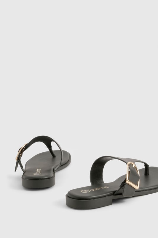 Stylish toe-post design with distinctive buckle detail for a contemporary twist
        Flat heel measuring between 0-2cm for all-day comfort and easy walking
        Sleek thong strap with smooth finish for minimal irritation between toes
        Durable sole with subtle grip pattern for poolside and beachfront stability
        Adjustable side buckle feature adds both functionality and visual interest
    
    These chic flip-flops from Boohoo combine practicality with understated style, perfect for the fashion-forward woman who values both comfort and aesthetic appeal. The distinctive buckle detail transforms a casual summer essential into a versatile accessory that works beyond the beach. Pair with flowing maxi dresses and oversized sunglasses for a relaxed daytime look, or team with cropped linen trousers and a fitted tee for casual weekend brunches. The flat design ensures comfortable wear throughout long summer days, whether you're navigating cobbled streets on holiday or attending a casual garden party. Their minimalist design makes them an excellent choice for packing light whilst maintaining style options - simply slip them on with denim shorts and a loose blouse for effortless warm-weather dressing that transitions seamlessly from day to evening.