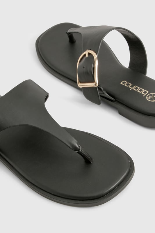 Stylish toe-post design with distinctive buckle detail for a contemporary twist
        Flat heel measuring between 0-2cm for all-day comfort and easy walking
        Sleek thong strap with smooth finish for minimal irritation between toes
        Durable sole with subtle grip pattern for poolside and beachfront stability
        Adjustable side buckle feature adds both functionality and visual interest
    
    These chic flip-flops from Boohoo combine practicality with understated style, perfect for the fashion-forward woman who values both comfort and aesthetic appeal. The distinctive buckle detail transforms a casual summer essential into a versatile accessory that works beyond the beach. Pair with flowing maxi dresses and oversized sunglasses for a relaxed daytime look, or team with cropped linen trousers and a fitted tee for casual weekend brunches. The flat design ensures comfortable wear throughout long summer days, whether you're navigating cobbled streets on holiday or attending a casual garden party. Their minimalist design makes them an excellent choice for packing light whilst maintaining style options - simply slip them on with denim shorts and a loose blouse for effortless warm-weather dressing that transitions seamlessly from day to evening.
