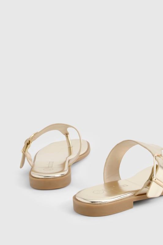 Stylish flip-flops featuring an eye-catching buckle detail for added interest
        Flat heel design (under 2cm) ensures all-day comfort without compromising on style
        Toe-post silhouette with a sleek strap across the foot for secure wear
        Metallic finish adds a touch of glamour to casual outfits
        Lightweight construction makes these perfect for holiday packing or summer days
    
    These chic flip-flops with distinctive buckle detailing offer the perfect blend of comfort and style for your summer wardrobe. The flat design ensures you can wear them all day without discomfort, whilst the metallic finish adds a touch of sophistication to even the most casual ensemble. Pair with flowing maxi dresses and oversized sunglasses for beach days, or team with cropped jeans and a simple tee for weekend brunches. The versatile design makes these sandals ideal for garden parties, casual shopping trips, or holiday sightseeing. Their slip-on style offers effortless convenience, whilst the decorative buckle provides a fashionable focal point that sets them apart from ordinary flip-flops. A true summer essential that works seamlessly from poolside to pavement, these sandals will quickly become your go-to footwear for the warmer months.