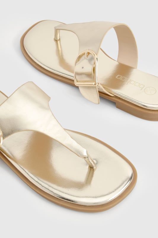 Stylish flip-flops featuring an eye-catching buckle detail for added interest
        Flat heel design (under 2cm) ensures all-day comfort without compromising on style
        Toe-post silhouette with a sleek strap across the foot for secure wear
        Metallic finish adds a touch of glamour to casual outfits
        Lightweight construction makes these perfect for holiday packing or summer days
    
    These chic flip-flops with distinctive buckle detailing offer the perfect blend of comfort and style for your summer wardrobe. The flat design ensures you can wear them all day without discomfort, whilst the metallic finish adds a touch of sophistication to even the most casual ensemble. Pair with flowing maxi dresses and oversized sunglasses for beach days, or team with cropped jeans and a simple tee for weekend brunches. The versatile design makes these sandals ideal for garden parties, casual shopping trips, or holiday sightseeing. Their slip-on style offers effortless convenience, whilst the decorative buckle provides a fashionable focal point that sets them apart from ordinary flip-flops. A true summer essential that works seamlessly from poolside to pavement, these sandals will quickly become your go-to footwear for the warmer months.