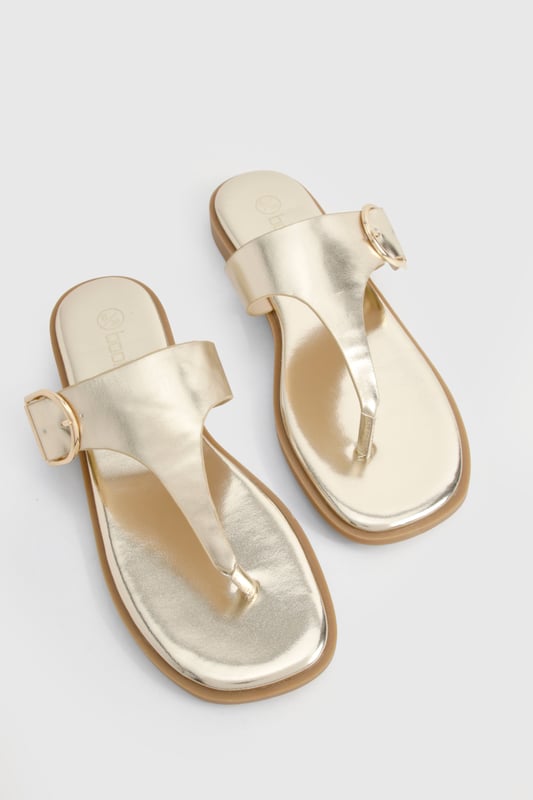 Stylish flip-flops featuring an eye-catching buckle detail for added interest
        Flat heel design (under 2cm) ensures all-day comfort without compromising on style
        Toe-post silhouette with a sleek strap across the foot for secure wear
        Metallic finish adds a touch of glamour to casual outfits
        Lightweight construction makes these perfect for holiday packing or summer days
    
    These chic flip-flops with distinctive buckle detailing offer the perfect blend of comfort and style for your summer wardrobe. The flat design ensures you can wear them all day without discomfort, whilst the metallic finish adds a touch of sophistication to even the most casual ensemble. Pair with flowing maxi dresses and oversized sunglasses for beach days, or team with cropped jeans and a simple tee for weekend brunches. The versatile design makes these sandals ideal for garden parties, casual shopping trips, or holiday sightseeing. Their slip-on style offers effortless convenience, whilst the decorative buckle provides a fashionable focal point that sets them apart from ordinary flip-flops. A true summer essential that works seamlessly from poolside to pavement, these sandals will quickly become your go-to footwear for the warmer months.