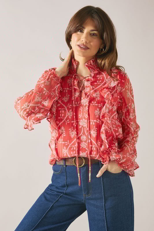 Floral Metallic Ruffle Blouse Elegant V-neckline with delicate tie detail for adjustable styling
Feminine ruffle detailing along the front and sleeves for a sophisticated touch
Lightweight viscose fabric offering comfort and graceful drape
Striking floral pattern that adds visual interest to any ensemble
Long sleeves with subtle volume for a flattering silhouette
This charming Wallis blouse combines sophistication with effortless style. The delicate ruffle detailing creates movement and dimension, whilst the V-neckline with tie feature allows for customisable styling. Perfect for daytime occasions, pair with wide-leg denim trousers and leather sandals for family gatherings or weekend brunches. For a more polished daywear look, tuck into tailored trousers and add a structured tote bag. The lightweight viscose fabric ensures comfort throughout the day, making this blouse ideal for transitional weather. The distinctive floral pattern works beautifully with neutral accessories, allowing the blouse to be the focal point of your outfit. Style with simple gold-toned jewellery to complement the feminine aesthetic of this versatile piece.