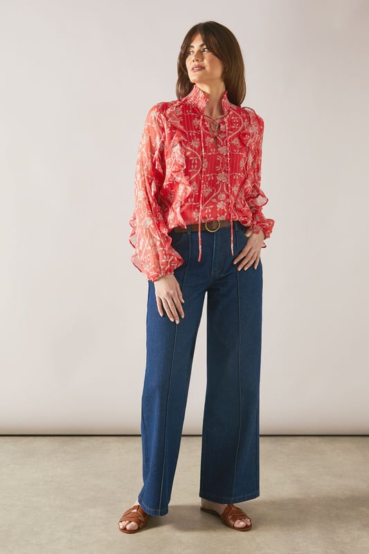 Floral Metallic Ruffle Blouse Elegant V-neckline with delicate tie detail for adjustable styling
Feminine ruffle detailing along the front and sleeves for a sophisticated touch
Lightweight viscose fabric offering comfort and graceful drape
Striking floral pattern that adds visual interest to any ensemble
Long sleeves with subtle volume for a flattering silhouette
This charming Wallis blouse combines sophistication with effortless style. The delicate ruffle detailing creates movement and dimension, whilst the V-neckline with tie feature allows for customisable styling. Perfect for daytime occasions, pair with wide-leg denim trousers and leather sandals for family gatherings or weekend brunches. For a more polished daywear look, tuck into tailored trousers and add a structured tote bag. The lightweight viscose fabric ensures comfort throughout the day, making this blouse ideal for transitional weather. The distinctive floral pattern works beautifully with neutral accessories, allowing the blouse to be the focal point of your outfit. Style with simple gold-toned jewellery to complement the feminine aesthetic of this versatile piece.