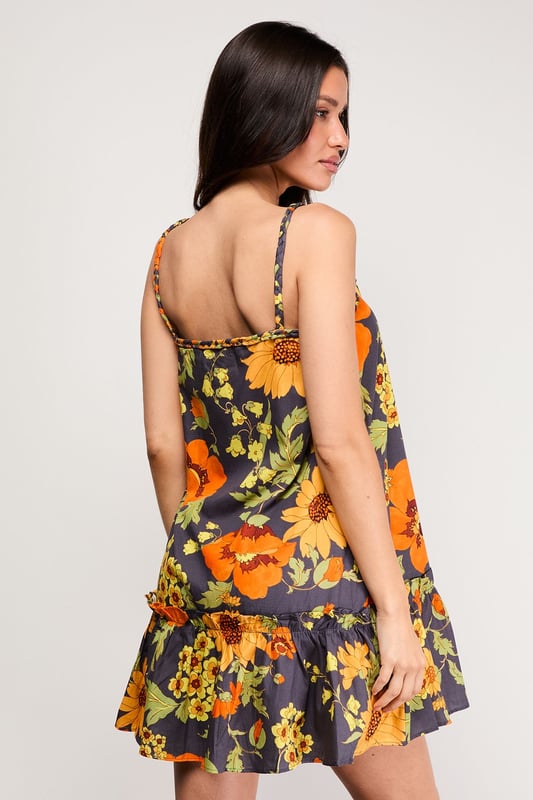 Distinctive plaited straps add a unique textural element to this breezy sundress
        Relaxed A-line silhouette with a feminine flounced hem for added movement
        Square neckline creates a flattering frame for the dcolletage
        Lightweight cotton poplin fabric ensures comfort during warmer days
        Bold floral print makes a confident statement while maintaining versatility
    
    This effortlessly chic sundress captures the essence of carefree summer style with its relaxed silhouette and eye-catching floral pattern. The plaited straps offer a distinctive design element that sets this piece apart, while the flounced hem adds a playful touch to your movement. Style with flat sandals as shown for daytime outings or family gatherings, or dress up with espadrille wedges and statement earrings for garden parties. The cotton poplin fabric ensures breathability during warmer weather, making this an ideal choice for holidays abroad or weekend brunches. Layer with a cropped denim jacket when temperatures cool, or wear over a fitted tee for a contemporary layered look. This versatile sundress transitions seamlessly from casual daytime events to relaxed evening occasions with just a few accessory changes.