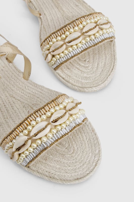 Wide fit espadrilles with eye-catching sequin embellishment across the front strap
        Comfortable flat heel measuring between 0-2cm for all-day wear
        Adjustable ankle strap with buckle fastening for a secure fit
        Traditional rope-style sole adds authentic espadrille character
        Metallic straps create a versatile, statement finish perfect for summer styling
    
    These wide fit espadrilles blend comfort with captivating style, making them the perfect companion for your summer wardrobe. The sequin-detailed front strap catches the light beautifully, whilst the metallic straps add a touch of glamour to casual outfits. Style with a flowing maxi dress and straw hat for beachside strolls, or pair with cropped linen trousers and a simple tee for weekend brunches. The adjustable ankle strap ensures these sandals stay securely in place, whilst the traditional espadrille base provides that quintessential holiday feel. Ideal for family gatherings, city explorations or garden parties, these versatile flats offer both comfort and style without compromising on either. The wide fit design ensures all-day comfort, making these the sandals you'll reach for throughout the warmer months.