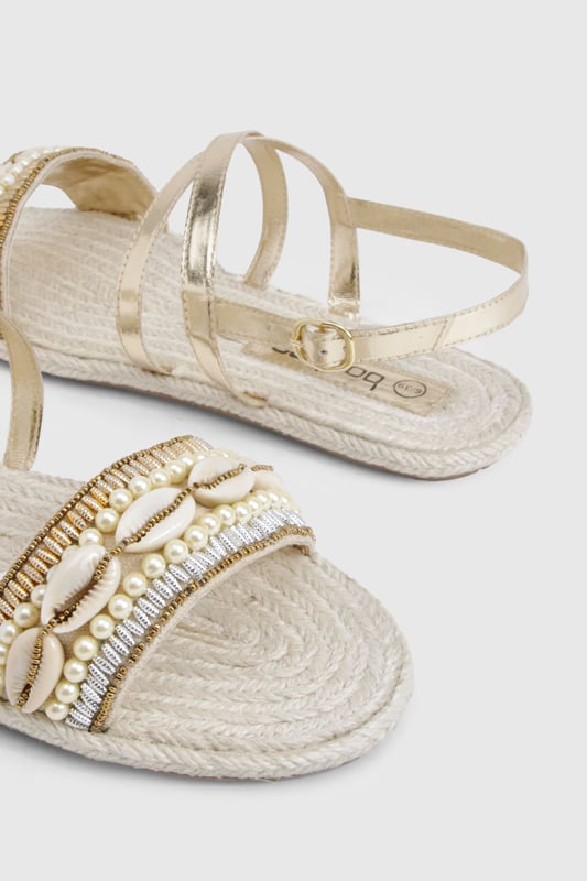 Wide fit espadrilles with eye-catching sequin embellishment across the front strap
        Comfortable flat heel measuring between 0-2cm for all-day wear
        Adjustable ankle strap with buckle fastening for a secure fit
        Traditional rope-style sole adds authentic espadrille character
        Metallic straps create a versatile, statement finish perfect for summer styling
    
    These wide fit espadrilles blend comfort with captivating style, making them the perfect companion for your summer wardrobe. The sequin-detailed front strap catches the light beautifully, whilst the metallic straps add a touch of glamour to casual outfits. Style with a flowing maxi dress and straw hat for beachside strolls, or pair with cropped linen trousers and a simple tee for weekend brunches. The adjustable ankle strap ensures these sandals stay securely in place, whilst the traditional espadrille base provides that quintessential holiday feel. Ideal for family gatherings, city explorations or garden parties, these versatile flats offer both comfort and style without compromising on either. The wide fit design ensures all-day comfort, making these the sandals you'll reach for throughout the warmer months.