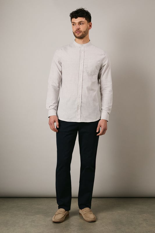 Off White Stripe Grandad Collar Long Sleeve Shirt Distinctive grandad collar design for a contemporary twist on classic shirting
Subtle stripe pattern woven throughout the fabric for understated visual interest
Long sleeves with buttoned cuffs offering versatile styling options
Chest pocket detail adding functional practicality to the design
Relaxed fit with a curved hem perfect for both tucked and untucked styling
This Maine grandad collar shirt combines timeless appeal with modern sensibility. The clean-lined design makes it an effortless addition to your casual wardrobe, whilst the distinctive collar creates a relaxed yet refined aesthetic. Style with dark trousers and loafers as shown for family gatherings or weekend brunches. For a more laid-back approach, pair with chinos and trainers for everyday wear. The versatile nature of this shirt makes it ideal for transitional weather - layer under a lightweight jacket when temperatures drop or wear alone with rolled sleeves during warmer days. The button-through front and woven fabric ensure comfort and ease of movement, making this shirt a practical choice for various casual occasions without compromising on style.