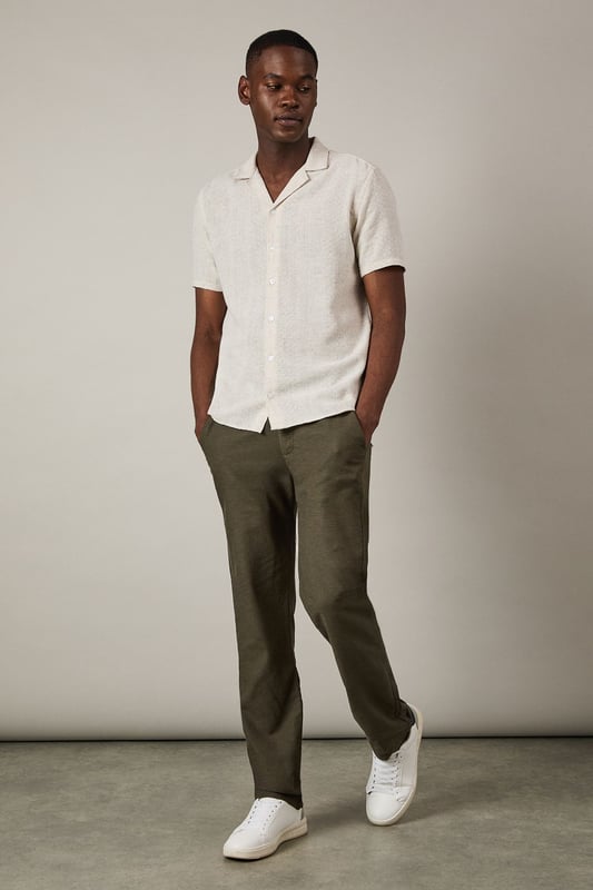 Textured woven fabric adds subtle dimension and visual interest to this casual shirt
        Classic revere collar design creates a relaxed yet refined neckline
        Short sleeves with neat hems perfect for warmer weather
        Button-through front with matching buttons for a clean finish
        Regular fit provides comfortable wear without being overly loose
    
    This Burton textured short sleeve shirt combines casual comfort with understated style. The natural textured fabric offers breathability whilst the revere collar adds a touch of laid-back sophistication that works brilliantly for various casual settings. Style it as shown with chinos or trousers in earthy tones for a balanced look, or pair with your favourite denim for weekend outings. The versatile design makes it ideal for summer barbecues, casual Friday office wear, or meeting mates at the local for a pint. Layer under a lightweight jacket when the temperature drops or wear unbuttoned over a plain t-shirt for a more relaxed approach. This shirt transitions effortlessly from daytime casual to evening gatherings, making it a practical addition to your warm-weather wardrobe that will serve you well for seasons to come.