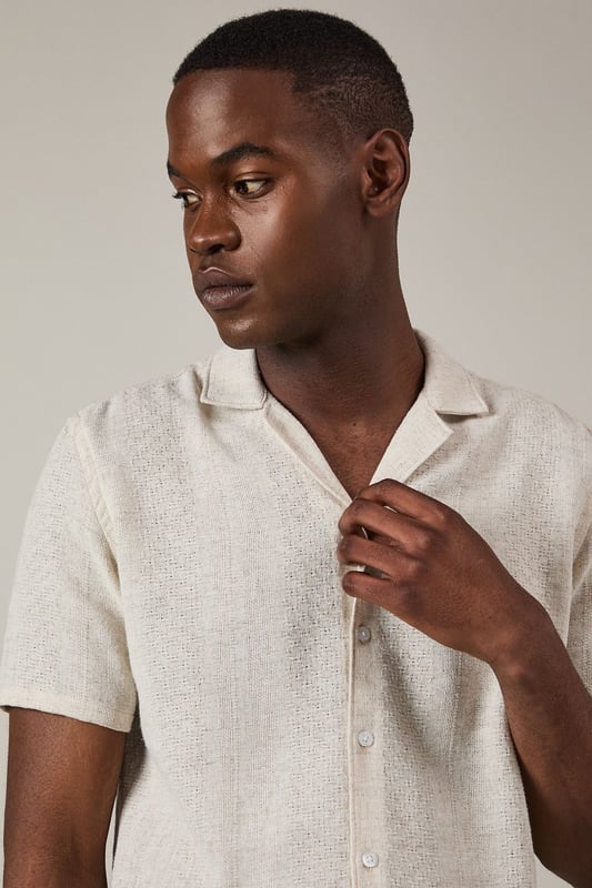 Textured woven fabric adds subtle dimension and visual interest to this casual shirt
        Classic revere collar design creates a relaxed yet refined neckline
        Short sleeves with neat hems perfect for warmer weather
        Button-through front with matching buttons for a clean finish
        Regular fit provides comfortable wear without being overly loose
    
    This Burton textured short sleeve shirt combines casual comfort with understated style. The natural textured fabric offers breathability whilst the revere collar adds a touch of laid-back sophistication that works brilliantly for various casual settings. Style it as shown with chinos or trousers in earthy tones for a balanced look, or pair with your favourite denim for weekend outings. The versatile design makes it ideal for summer barbecues, casual Friday office wear, or meeting mates at the local for a pint. Layer under a lightweight jacket when the temperature drops or wear unbuttoned over a plain t-shirt for a more relaxed approach. This shirt transitions effortlessly from daytime casual to evening gatherings, making it a practical addition to your warm-weather wardrobe that will serve you well for seasons to come.