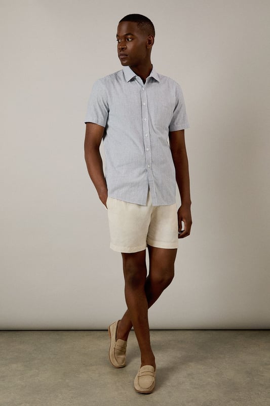 Navy Fine Stripe Short Sleeve Shirt Classic fine stripe pattern for a refined casual look
Short sleeves with neat hems for warm-weather comfort
Traditional collar with structured shape
Convenient chest pocket for added functionality
Regular fit design offering ease of movement throughout the day
This Burton short sleeve shirt combines timeless style with everyday practicality. The fine stripe pattern creates visual interest while maintaining versatility for various occasions. Pair with chino shorts and loafers as shown for a smart casual weekend look perfect for beer garden gatherings or family barbecues. For cooler evenings, layer under a lightweight jumper or team with dark denim jeans and trainers for pub outings with mates. The woven fabric offers breathability and comfort during sporting events or casual match viewings. This shirt transitions effortlessly from daytime casual to evening socialising, making it an essential addition to any practical British wardrobe. A reliable choice for the man who values classic style with contemporary appeal.