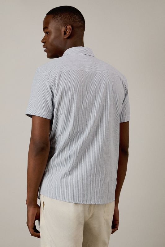 Navy Fine Stripe Short Sleeve Shirt Classic fine stripe pattern for a refined casual look
Short sleeves with neat hems for warm-weather comfort
Traditional collar with structured shape
Convenient chest pocket for added functionality
Regular fit design offering ease of movement throughout the day
This Burton short sleeve shirt combines timeless style with everyday practicality. The fine stripe pattern creates visual interest while maintaining versatility for various occasions. Pair with chino shorts and loafers as shown for a smart casual weekend look perfect for beer garden gatherings or family barbecues. For cooler evenings, layer under a lightweight jumper or team with dark denim jeans and trainers for pub outings with mates. The woven fabric offers breathability and comfort during sporting events or casual match viewings. This shirt transitions effortlessly from daytime casual to evening socialising, making it an essential addition to any practical British wardrobe. A reliable choice for the man who values classic style with contemporary appeal.
