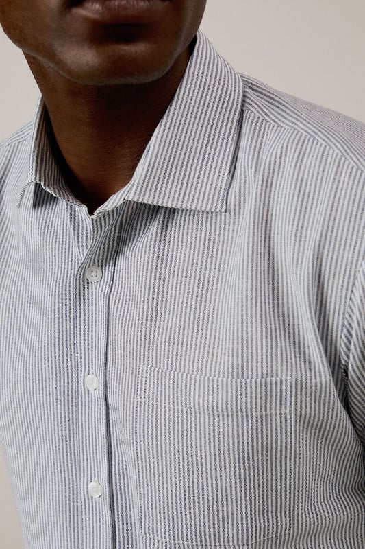 Navy Fine Stripe Short Sleeve Shirt Classic fine stripe pattern for a refined casual look
Short sleeves with neat hems for warm-weather comfort
Traditional collar with structured shape
Convenient chest pocket for added functionality
Regular fit design offering ease of movement throughout the day
This Burton short sleeve shirt combines timeless style with everyday practicality. The fine stripe pattern creates visual interest while maintaining versatility for various occasions. Pair with chino shorts and loafers as shown for a smart casual weekend look perfect for beer garden gatherings or family barbecues. For cooler evenings, layer under a lightweight jumper or team with dark denim jeans and trainers for pub outings with mates. The woven fabric offers breathability and comfort during sporting events or casual match viewings. This shirt transitions effortlessly from daytime casual to evening socialising, making it an essential addition to any practical British wardrobe. A reliable choice for the man who values classic style with contemporary appeal.