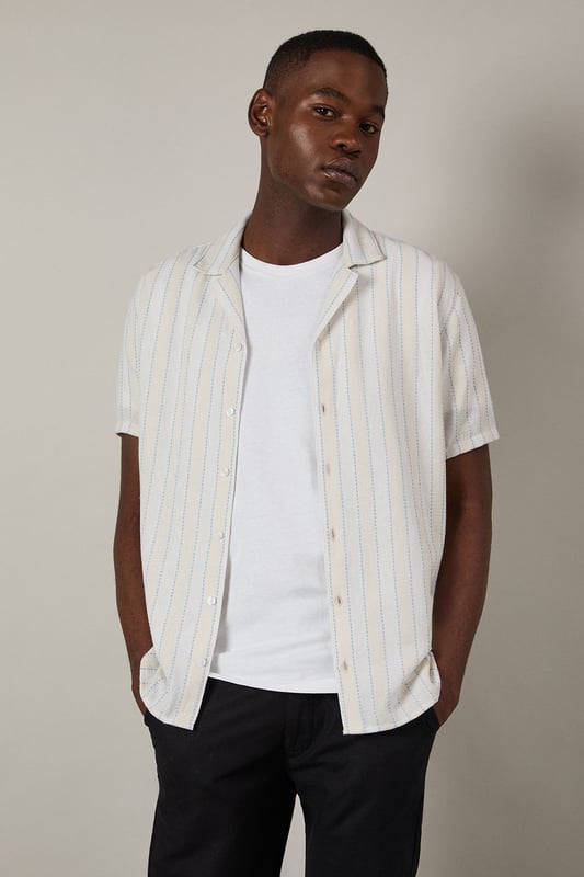 Textured stripe pattern adds subtle dimension to this classic short sleeve shirt
        Revere collar design offers a relaxed, open neckline perfect for warmer days
        Button-through front with clean finishing for effortless style
        Relaxed fit through the body provides comfortable all-day wear
        Versatile woven fabric with textural interest that maintains its shape throughout the day
    
    This Burton textured stripe shirt brings casual sophistication to your everyday wardrobe. The revere collar creates a laid-back yet put-together look that works brilliantly for various occasions. Style it as shown with dark trousers and a simple white t-shirt underneath for an effortless weekend ensemble, perfect for meeting mates at the pub or casual family gatherings. The textured stripe pattern adds character without overwhelming, making this shirt an excellent choice for summer barbecues or watching the match. For a smarter approach, pair with chinos and loafers. The versatile design transitions seamlessly from daytime casual to evening drinks, embodying Burton's commitment to practical yet stylish menswear that fits comfortably into the modern British man's lifestyle.